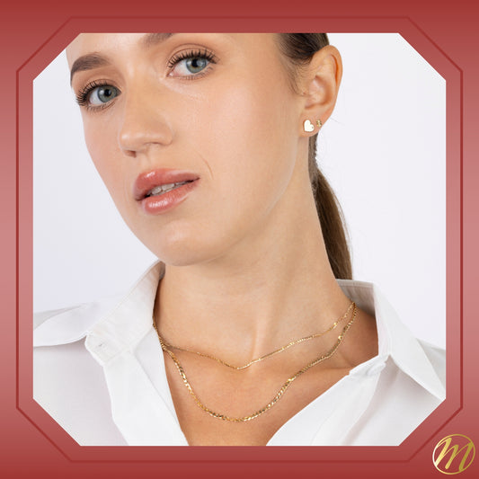 14K yellow gold curb link chain necklace worn on a white blouse with layered look